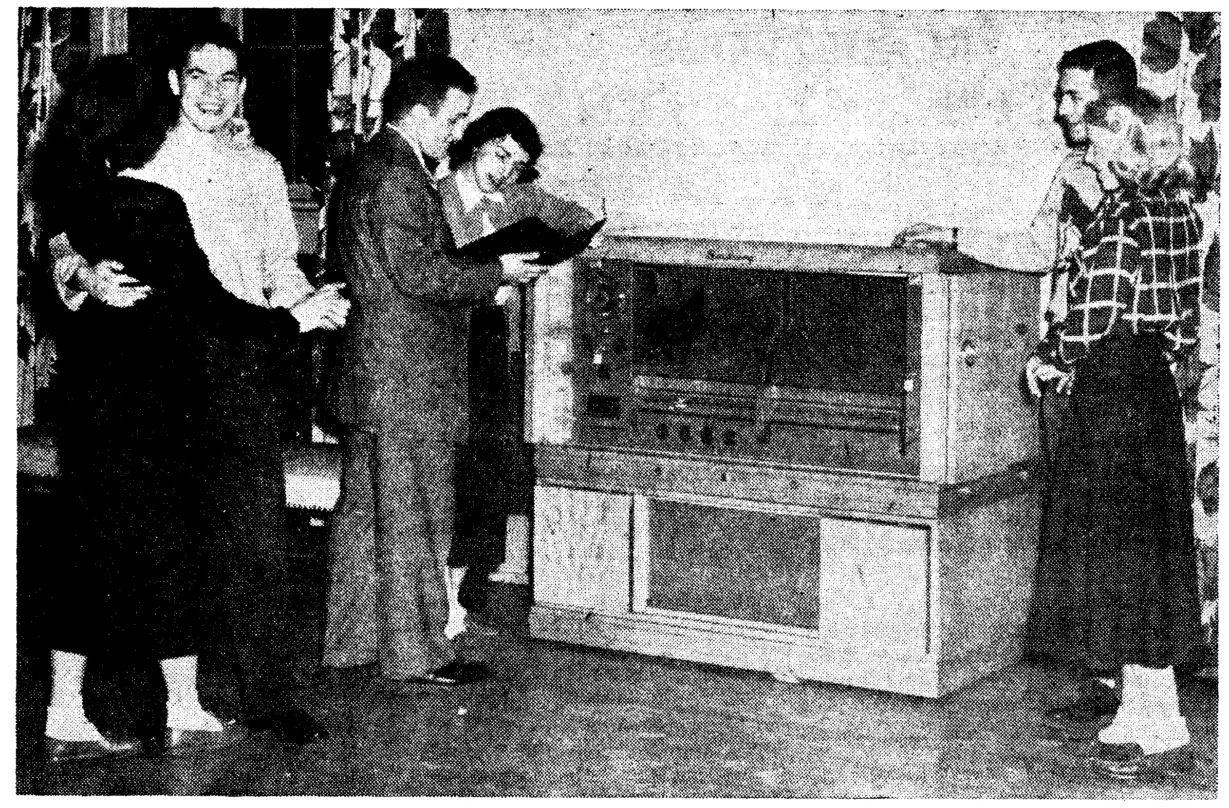 One couple dancing and two couples examining Seeburg 200 jukebox