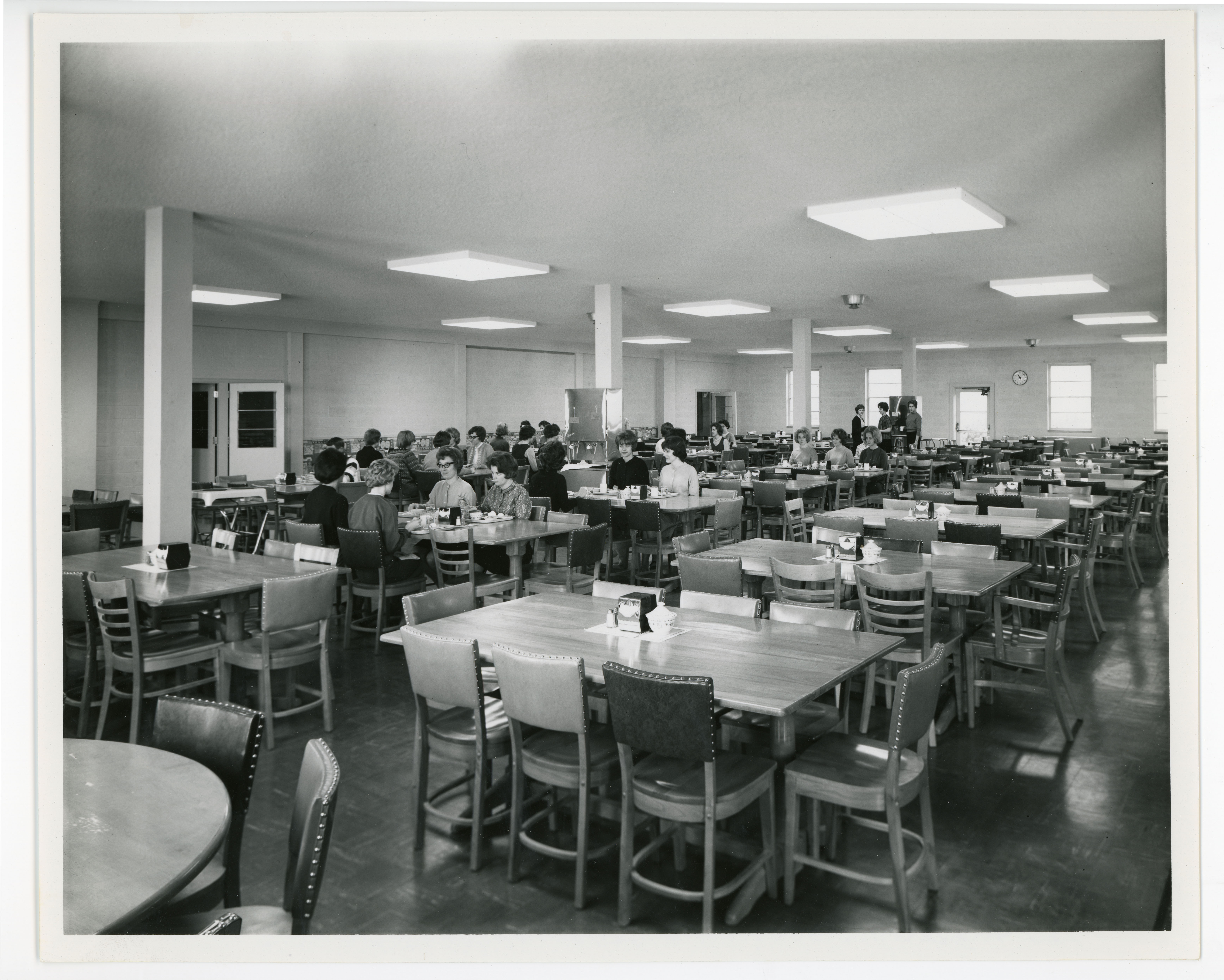 Dining room with students seated at tables mostly at back wall
