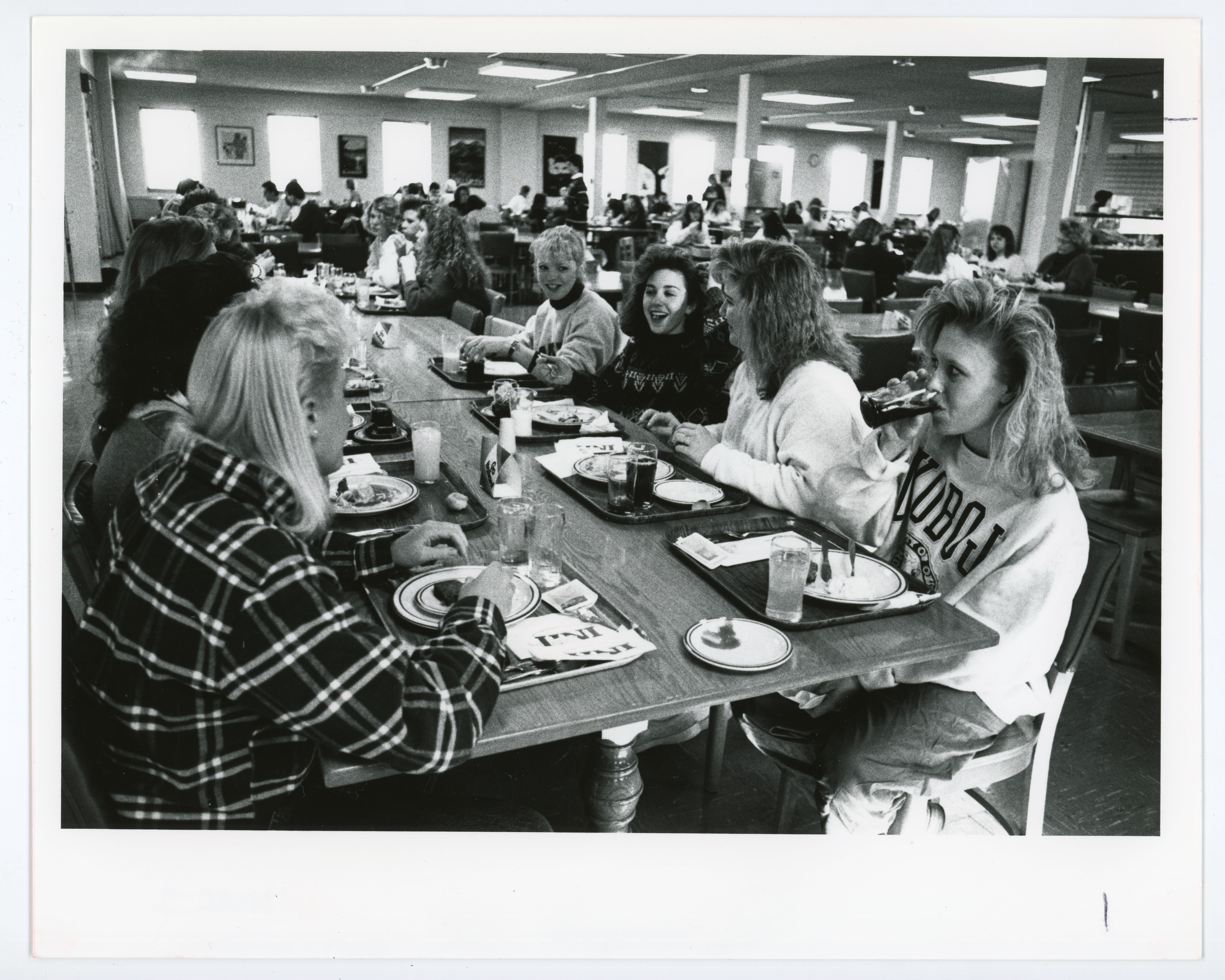 People seated and eating at tables in full dining center