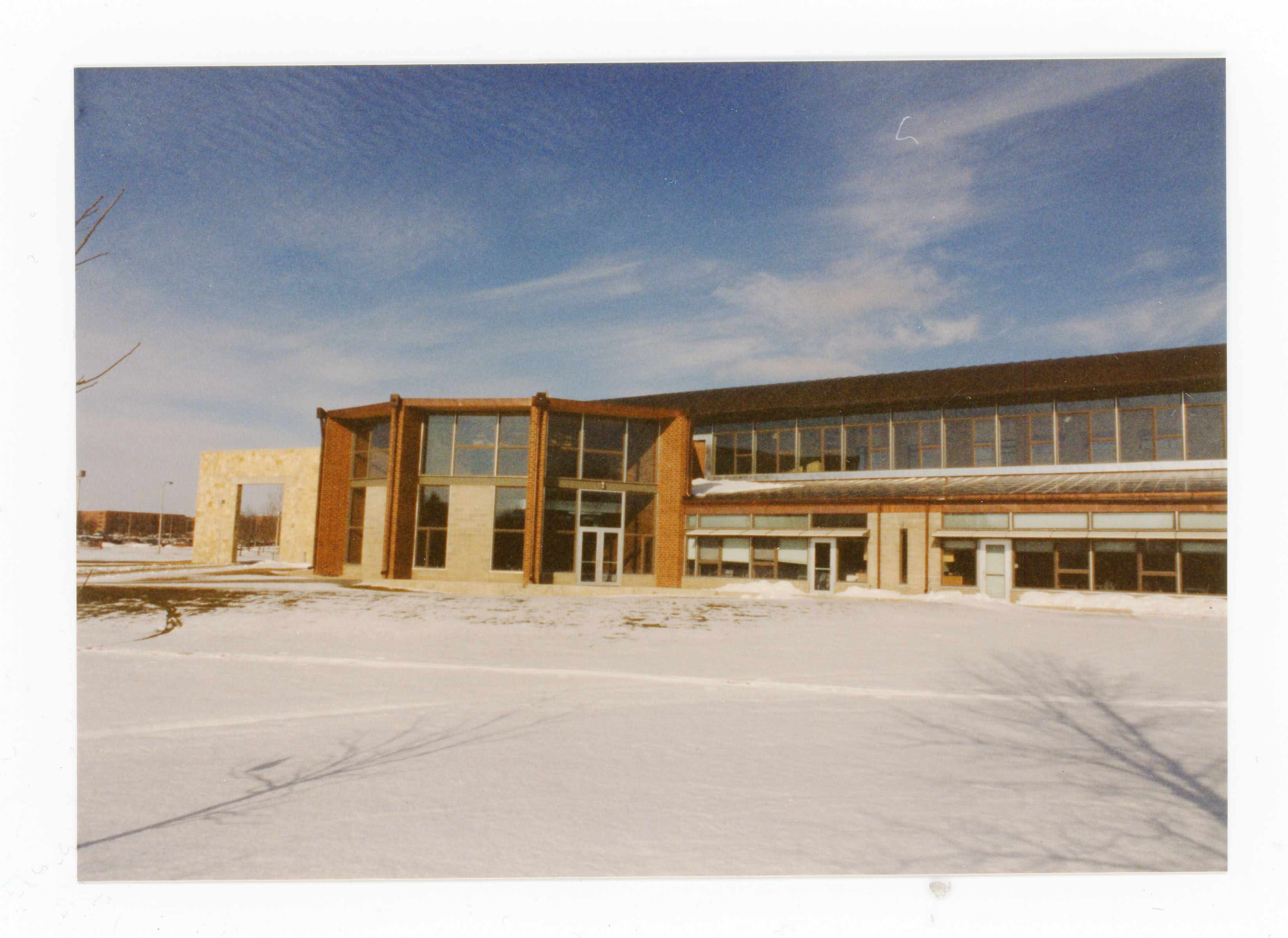Exterior of building with snow on the ground, another building visible in back left