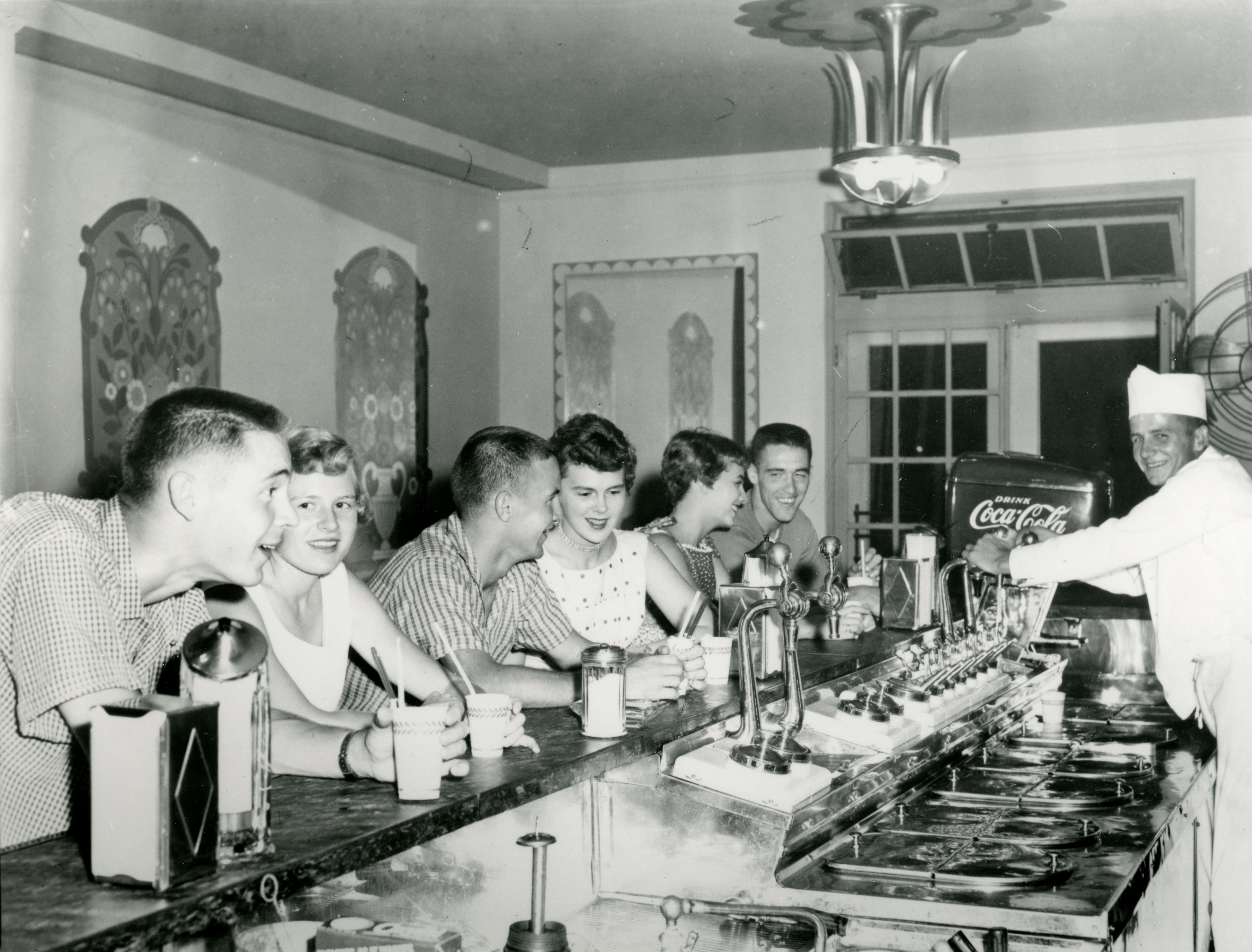 Three couples being served by a man at the Commons soda fountain counter