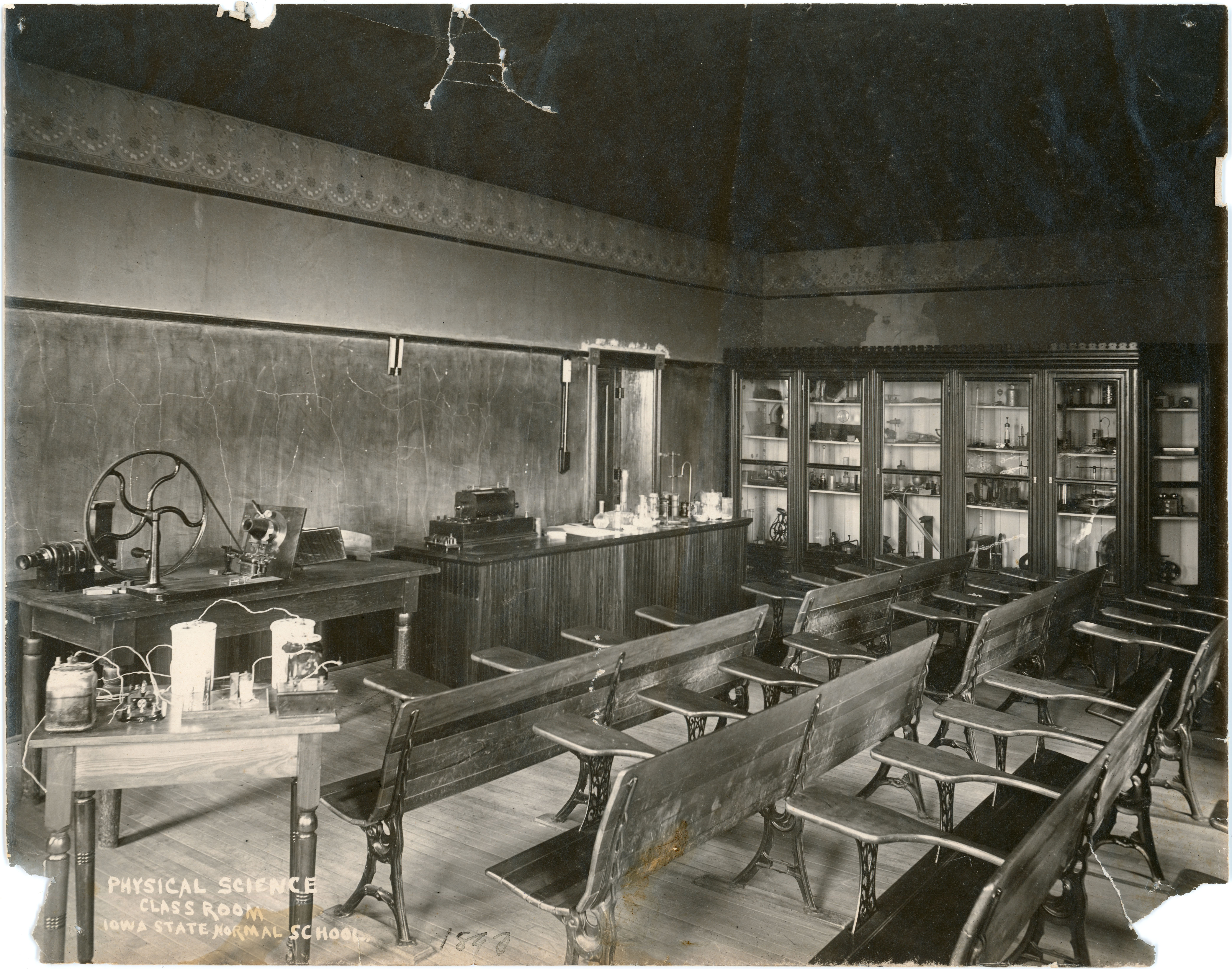 Classroom with desks, tables, and vials in cabinets