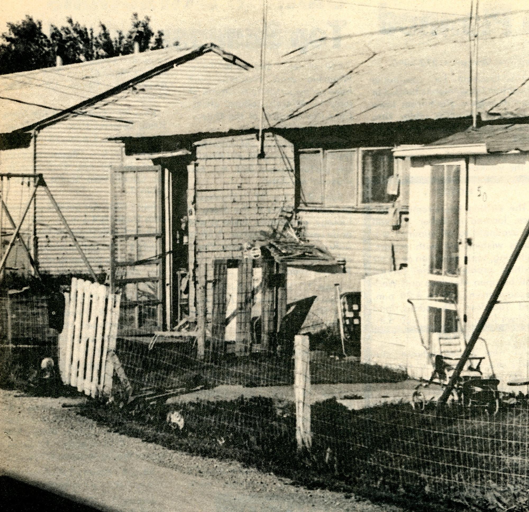 Steel-sided building with general wear and tear, pieces of roof and siding falling off
