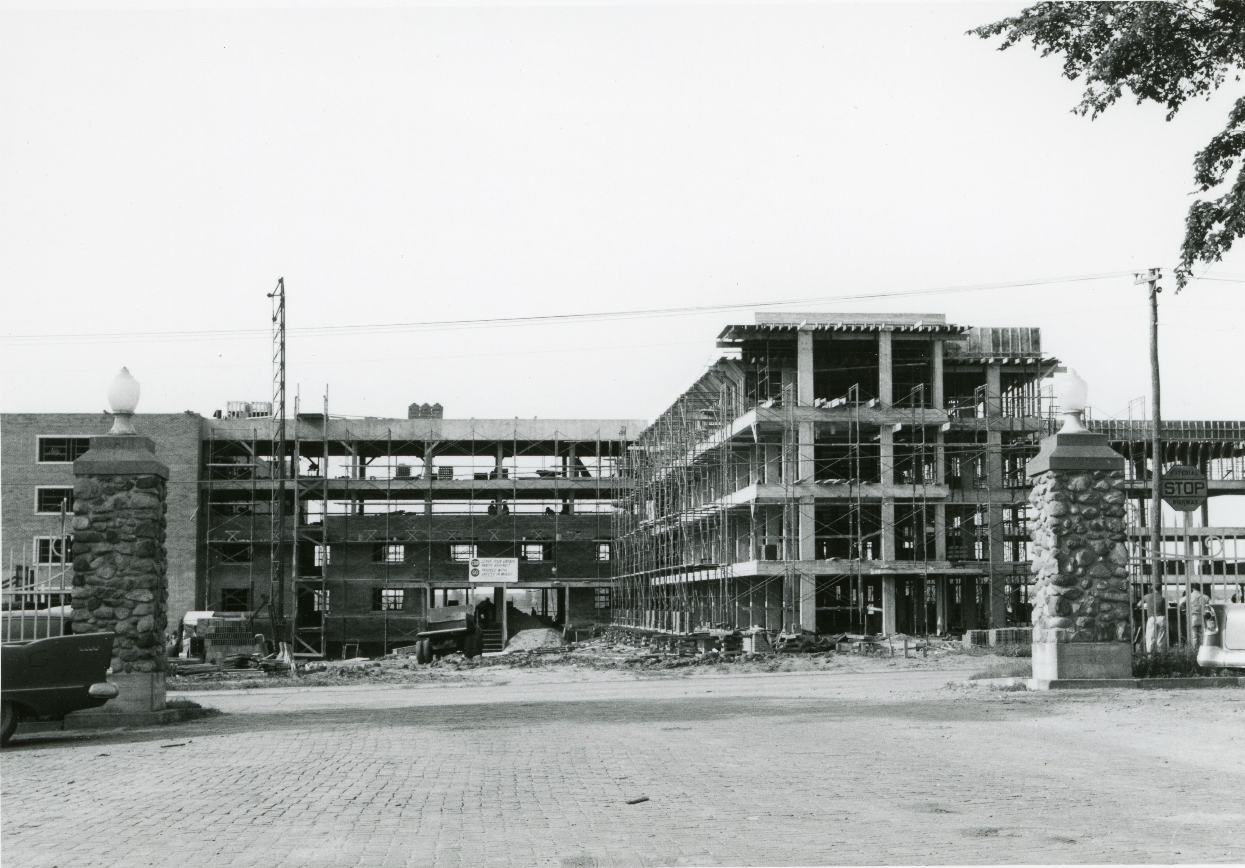 L-shaped building under construction, supports in place and scaffolding around