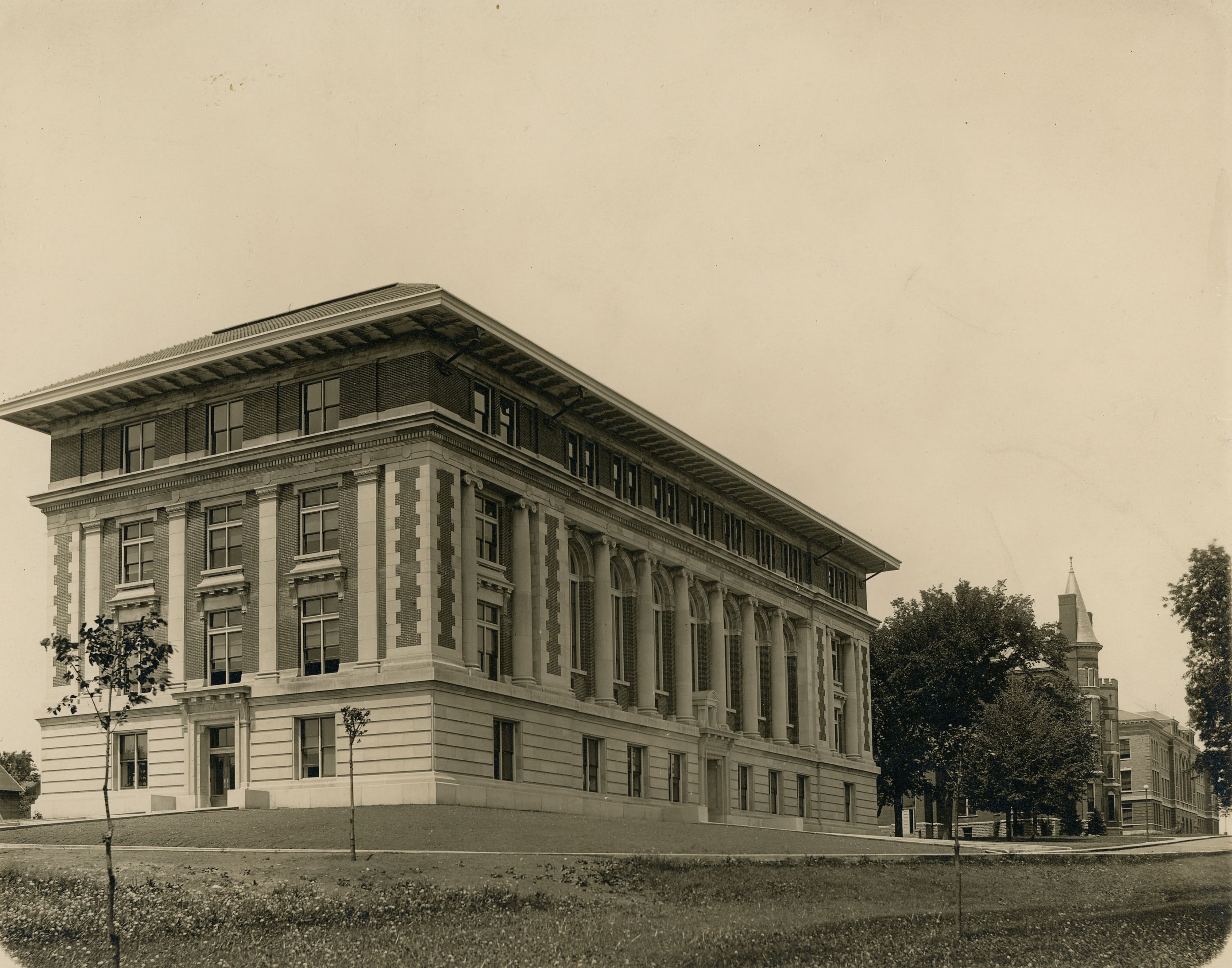 Brick and limestone building with arched windows and pillars on front and decorative patterns in the stonework at the corners