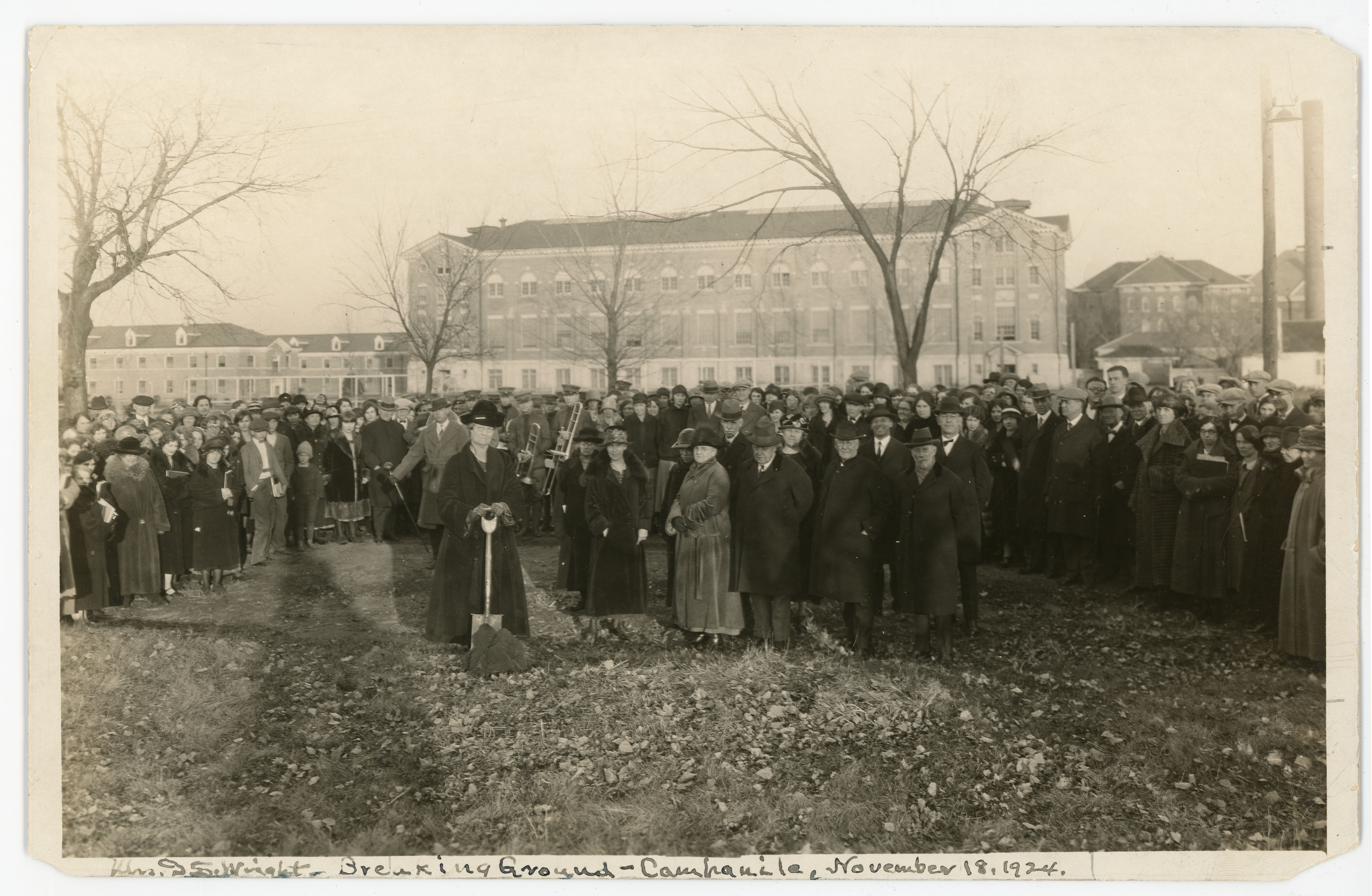 Crowd outside with campus buildings in background, handwriting on image reads "Mrs. D.S. Wright - breaking ground - Campanile, November 18, 1924"