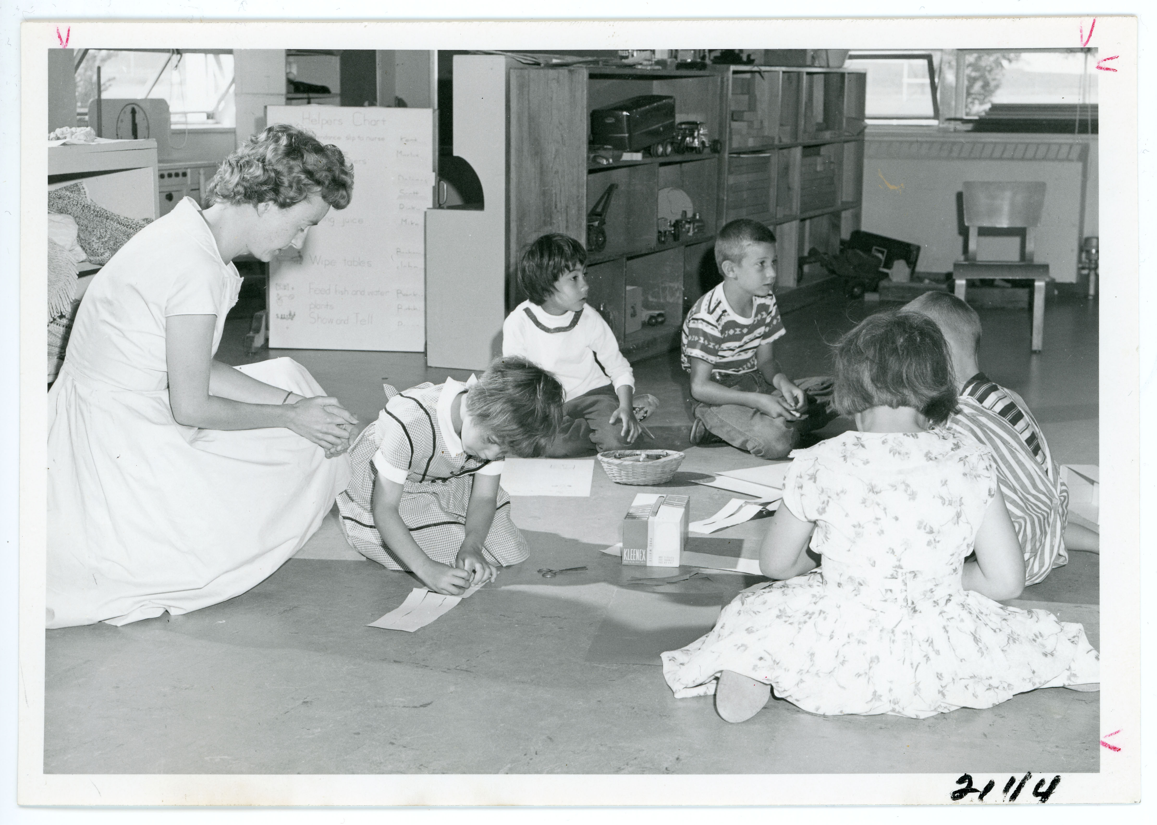 Teacher and elementary school students sitting on a classroom floor