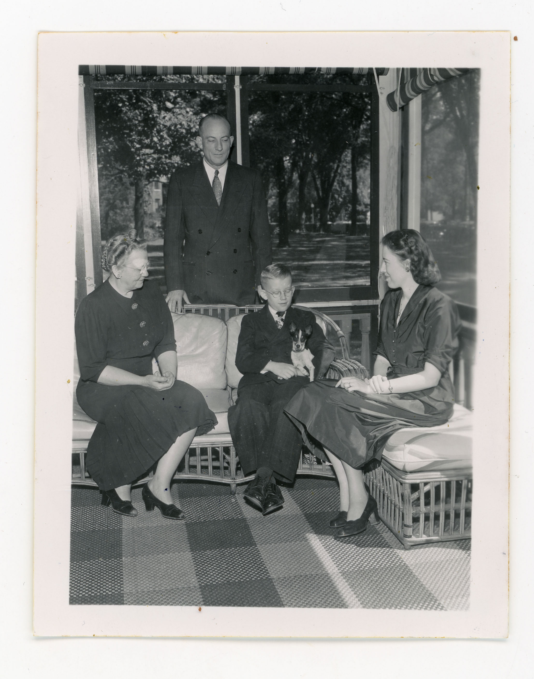 President Price and his family sitting on a porch with their dog