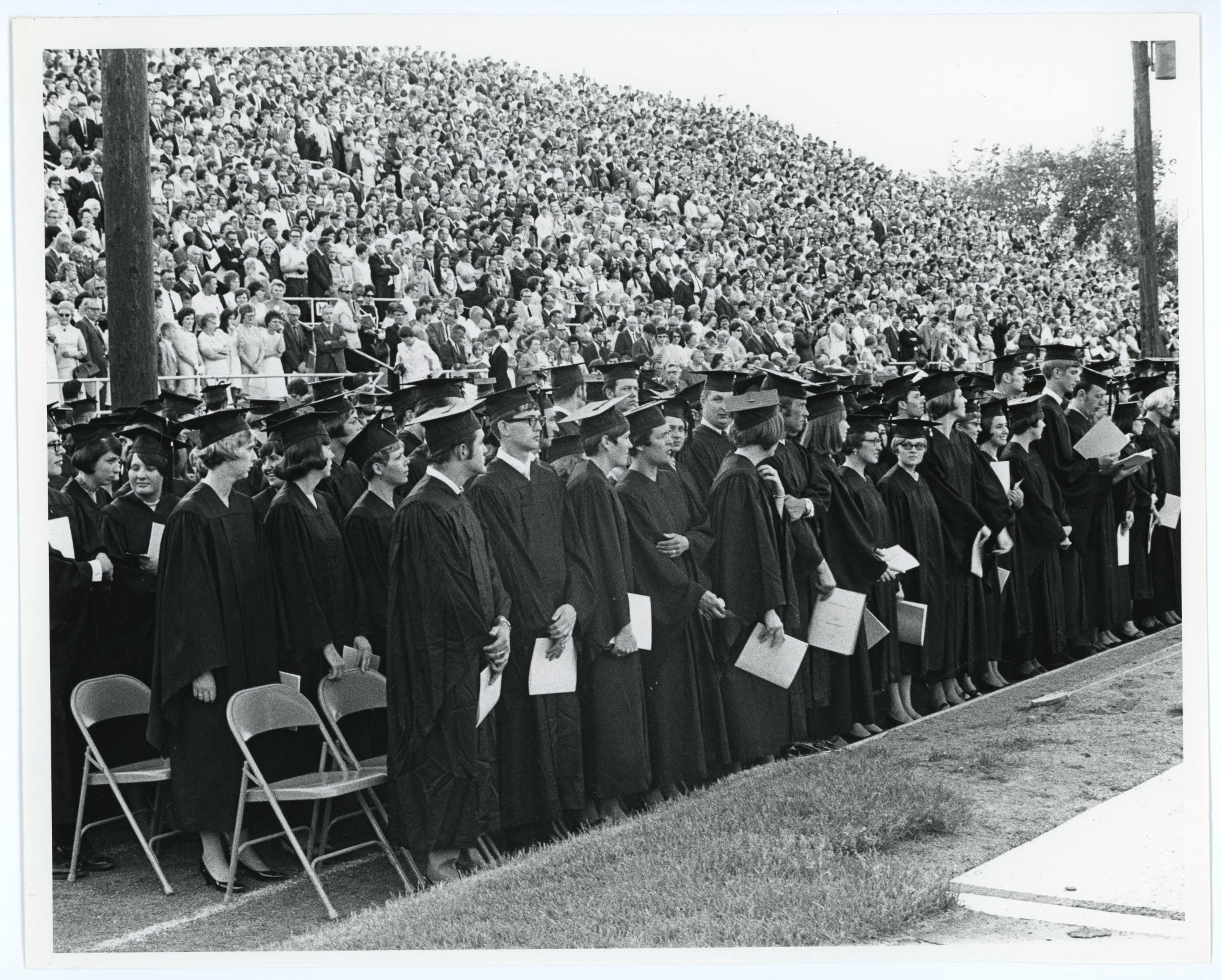 Students standing during Commencement ceremony at Latham Stadium