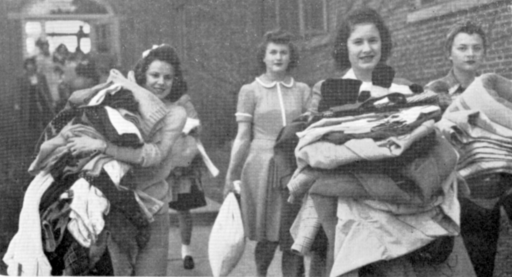 Women carrying clothes and other items from Bartlett Hall to Lawther Hall