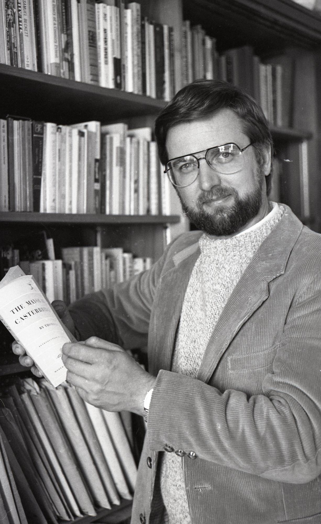 Professor Scott Cawelti posing next to a bookshelf