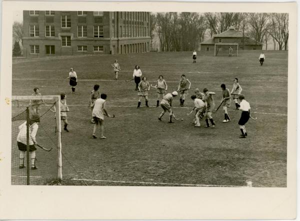 Women playing field hockey, 1930