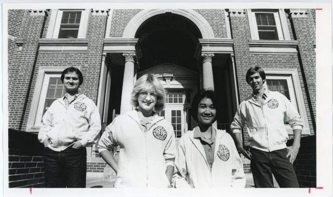 Photograph of four students standing outside of Bartlett Hall, 1980.