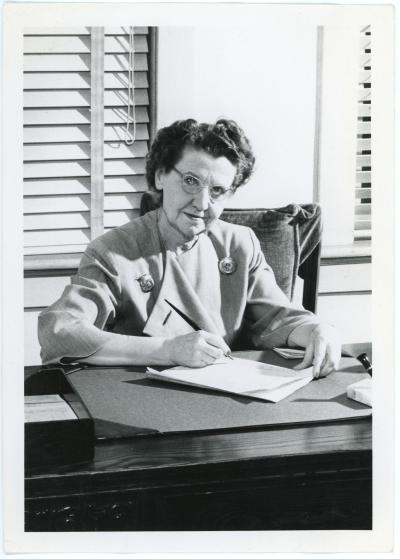 Photo of Sadie B. Campbell sitting at her desk, undated.
