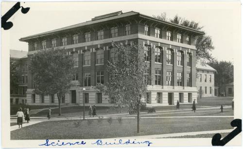 Exterior image of Begeman Hall with students and a single car in the foreground