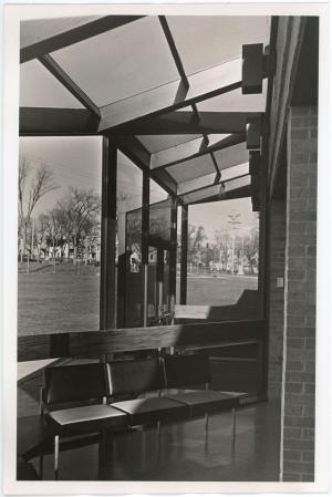 Three chairs sitting in front of a window near an enterance to the Biology Research Center