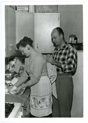 Photograph of two individuals doing dishes in a College Courts unit