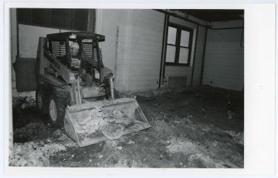 Photograph of a loader cleaning up debris from the Lang Hall interior