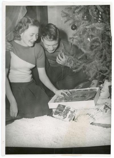 Couple opening presents under the Christmas tree