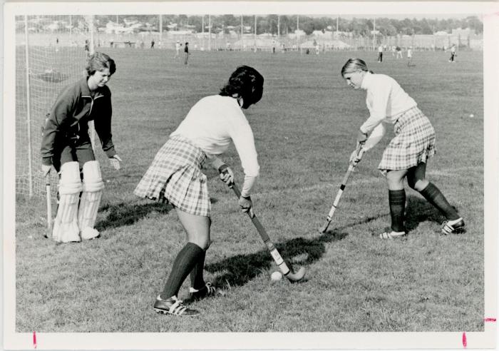 Women playing field hockey, 1975