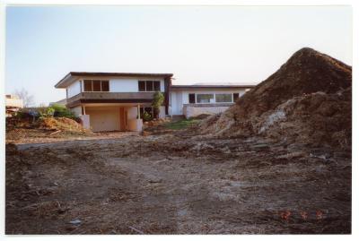 Photo of Professor Willis Wagner's house behind a pile of dirt and land that has been cleared for the Panther Village parking lot