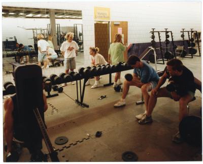 Photo of several students using the Physical Education Center weight room
