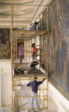 People on scaffolding working on remounting the restored Dodge murals
