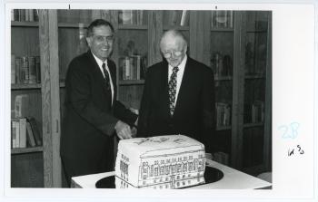 President Curris (left) and Homer Cully (right) cutting a cake shaped like Seerley Hall