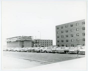 Photo of student parking lot, a completed Rider Hall and Shull Hall under construction are visible in the background
