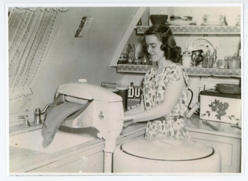 Woman using a squeeze dryer over a Sunset Village unit's kitchen sink