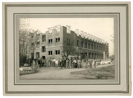Photograph of the Vocational Building construction crew taken outside of the partially constructed building