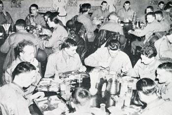 Photograph of several Army Air Force men eating a meal in the Commons