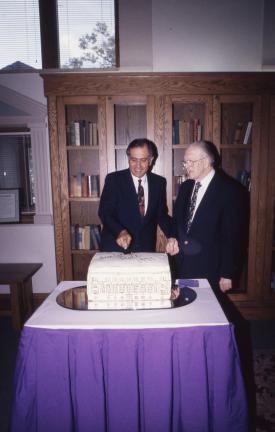 President Curris (left) and Homer Cully (right) cutting a cake shaped like Seerley Hall