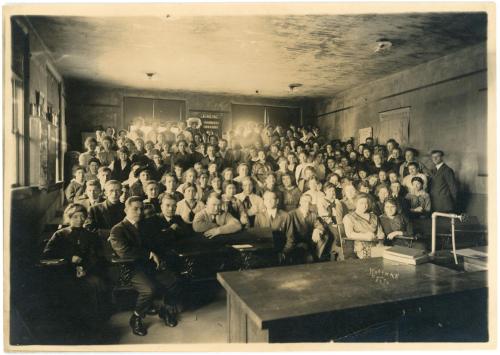Group photo of a chemistry class all sitting/standing in old lecture hall seats