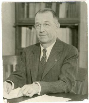 Albert C. Fuller sitting at a desk with paperwork