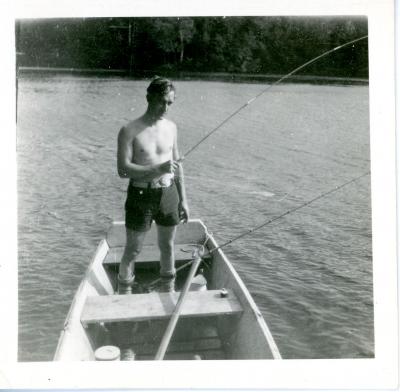 Eugene Francis Grossman fishing while standing inside of a fishing boat. Eugene Francis Grossman photograph, in the Eugene Francis Grossman Papers 1896-1965, #MsC-38, photographs of family and friends, box 1, University of Northern Iowa.