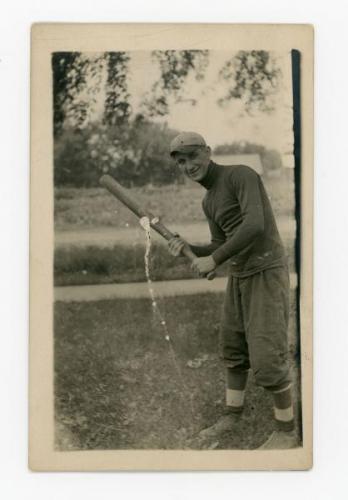 Eugene Grossman posing with a baseball bat.