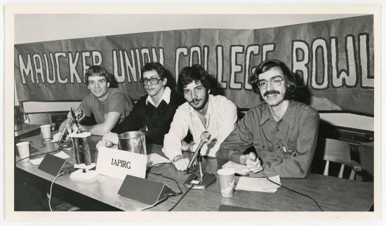 Four men sitting at a table in front of a Maucker Union College Bowl banner.