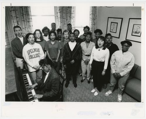 A group of singers singing while a man plays the keyboard.