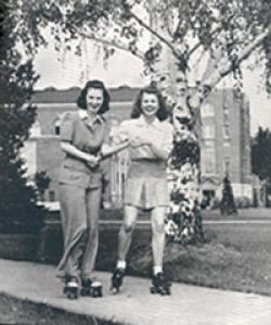 Photo of two women roller skating on campus