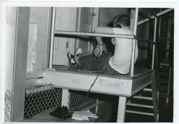 Student sits at the top of a staircase to take a call in the Latham Stadium dorms