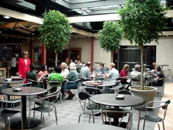 People sitting at tables in the Piazza skylight area in Redeker Center