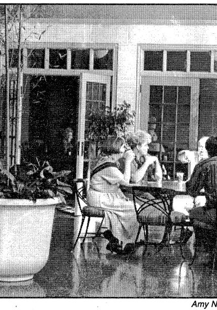 People having refreshments on terrace at tables with umbrellas