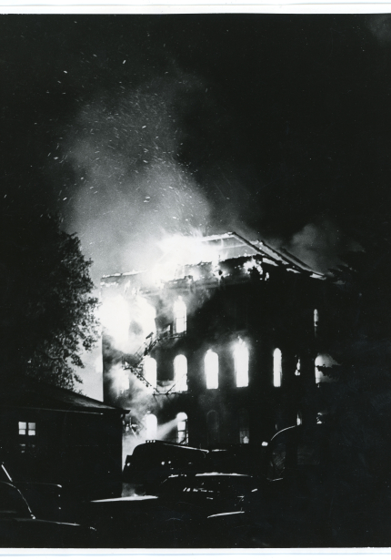 Building on fire at night with flames coming out the top and windows