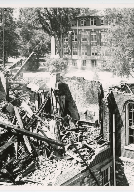 Ruins of building after fire damage, burned timbers and bricks collapsed into building remains