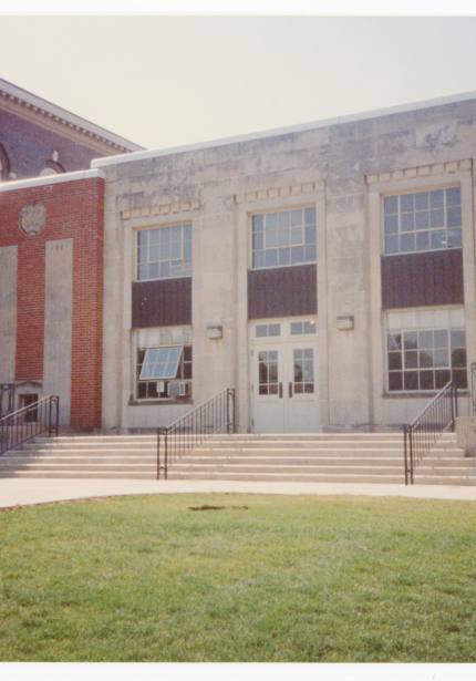 North side of Commons building with staircase, entrance, and metal decorative railing