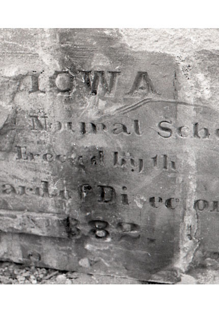 Block of stone with words mostly intact reading Iowa Normal School Erected by the Board of Directors 1882