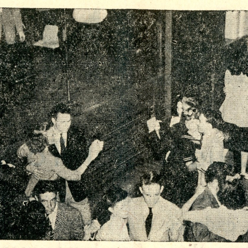 Couples dancing and a band playing in a ballroom, printed in newspaper