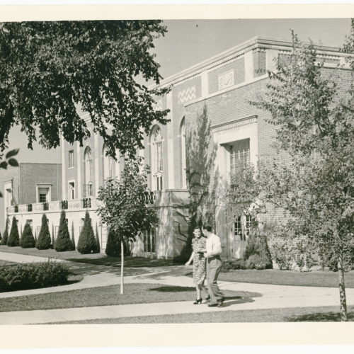 Woman and man walking on sidewalk in front of the Commons