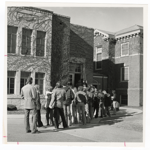 Crowd of people lined up outside the Commons building to enter it